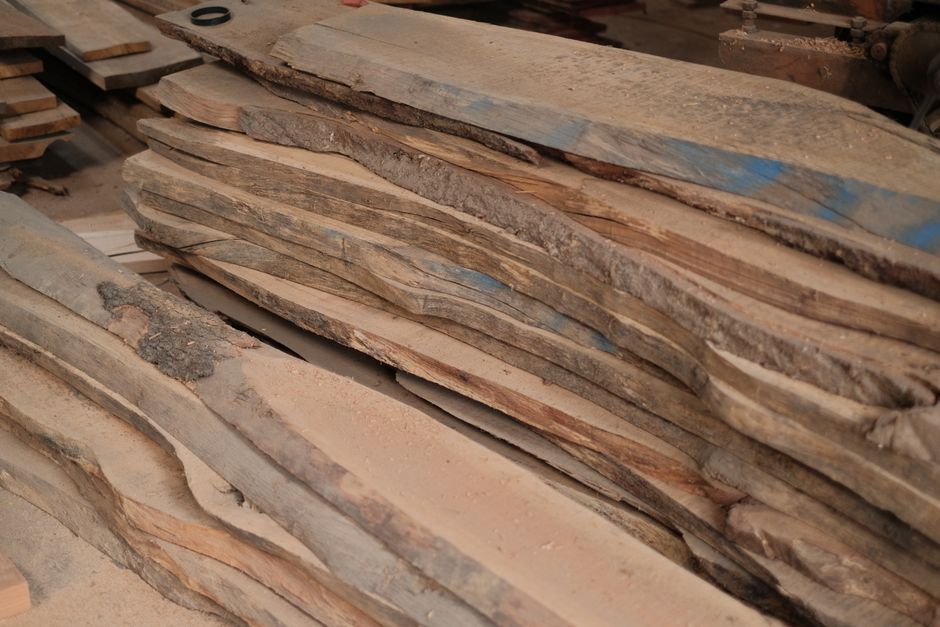 Stack of rough sawn hardwood boards with bark edges